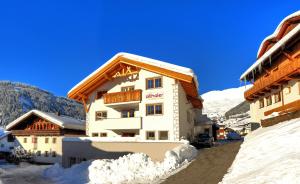 a building with snow on the ground in front of it at Apart Althaler in Serfaus