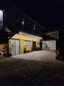 a yellow building with lights on it at night at Maga hospedagem in Penha