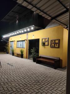 a building with a bench in a courtyard at night at Maga hospedagem in Penha