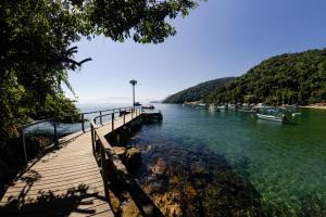a wooden dock with boats in the water at Ponta Da Barca in Praia Vermelha