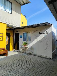 a building with a table and chairs in a courtyard at Maga hospedagem in Penha