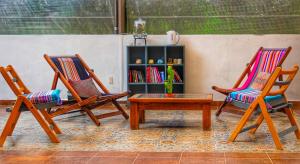 due sedie e un tavolo e una libreria di Hotel Ocho Barrios a San Cristóbal de Las Casas