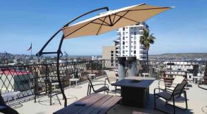 a patio with a table and chairs and an umbrella at Cabaña DW in Tijuana