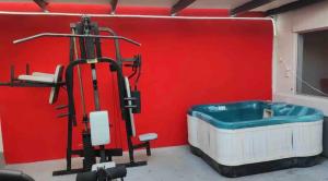 a bath tub in a room with a red wall at Cabaña DW in Tijuana
