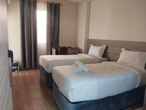 a hotel room with two beds and a window at Nour Echames Hotel - Chéraga in Cheraga