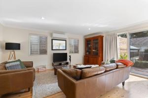 un soggiorno con un divano e una televisione di Cottage on Kent a Toowoomba