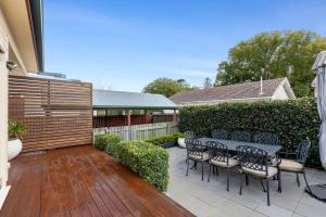 un patio con tavolo, sedie e una recinzione di Cottage on Kent a Toowoomba