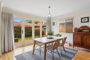 una sala da pranzo con tavolo e sedie di Cottage on Kent a Toowoomba Altre 6 foto