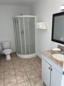 La salle de bains est pourvue d'une douche, de toilettes et d'un lavabo. dans l'établissement Motel la Siesta de Gascon, à Terrebonne