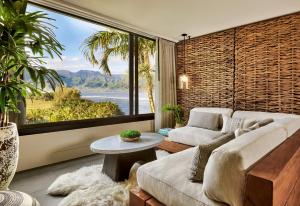 a living room with a couch and a large window at 1 Hotel Hanalei Bay in Princeville