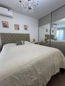 a bedroom with a large bed and a chandelier at Premium tower apart Parking gratis in Cordoba +29 photos