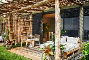 a bed and a table on a wooden patio at 1 Hotel Hanalei Bay in Princeville