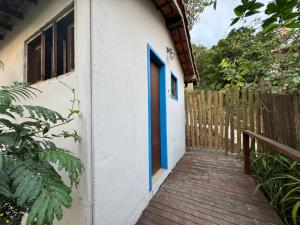 a blue door on a building with a wooden walkway at Pousada Peninsula de Buzios in Búzios