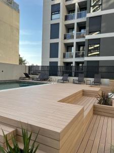 a patio with chairs and a pool in front of a building at Premium tower apart Parking gratis in Cordoba