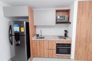 a kitchen with a stainless steel refrigerator and a microwave at Hermoso Apartamento tipo Loft en Rodadero Santa Marta in Santa Marta