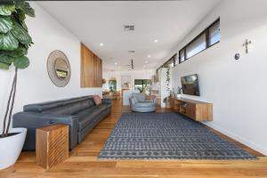Una sala de estar con un sofá y un televisor. en Luxe Oasis Adamstown, en Adamstown