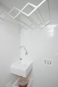 a white bathroom with a sink and a mirror at Hermoso Apartamento tipo Loft en Rodadero Santa Marta in Santa Marta