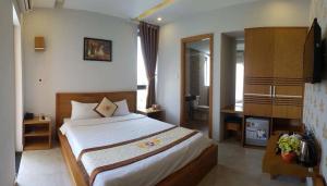 ダナンにあるTân Hoàng Long Hotel DN by - BAY LUXURYの大きなベッドと机のある寝室