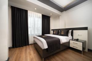 a bedroom with a large bed and a window at Bakırk&ouml;y Zeugma Suit Otel in Istanbul