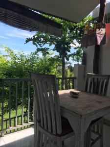 a wooden table and two chairs on a balcony at Azona Greens Uluwatu in Uluwatu