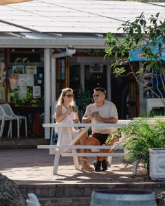 大克佩爾的住宿－大克佩爾島海德威度假酒店，坐在长凳上的男人和女人
