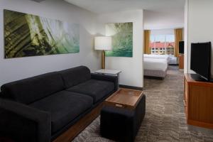 a living room with a couch and a television at SpringHill Suites by Marriott Orlando Convention Center in Orlando