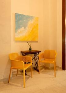 two chairs and a table in a room with a painting at Tecnohotel Casa Villamar in Progreso