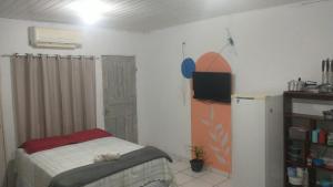 um quarto com uma cama e uma televisão em Suíte próximo ao Shopping em Rio Branco