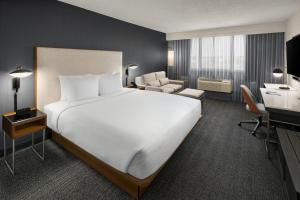 紐哈芬的住宿－耶魯紐黑文萬怡​​酒店，酒店客房设有一张大床和一张书桌。