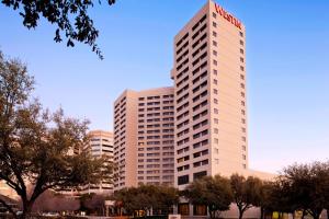 a tall white building with a red sign on it at The Westin Dallas Park Central in Dallas