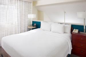 オンタリオにあるResidence Inn Ontario Airportのベッドルーム(白い大型ベッド、白い枕付)