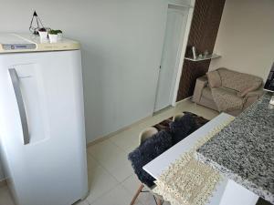 a kitchen with a white refrigerator and a table at Apto novo, mobiliado e acochegante in Boa Vista