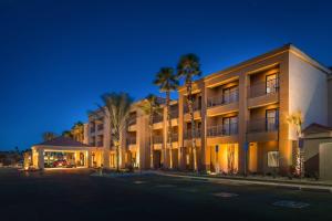 a large building with palm trees in front of it at Courtyard Palm Desert in Palm Desert