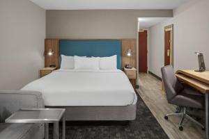 a hotel room with a large bed and a desk at Courtyard Newport News Yorktown in Newport News +12 photos