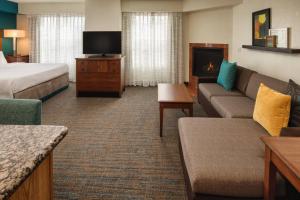 a hotel room with a couch and a tv at Residence Inn by Marriott Portland North in Portland