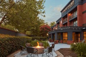 a courtyard with chairs and a fire pit in front of a building at Courtyard Newport News Yorktown in Newport News