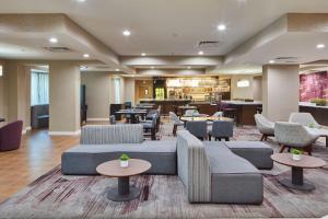a hotel lobby with couches and tables and chairs at Courtyard Newport News Yorktown in Newport News