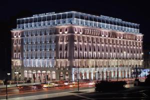 a large building at night with traffic in front of it at Hotel Grande Bretagne, a Luxury Collection Hotel, Athens in Athens
