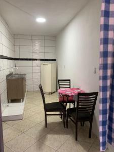 a kitchen with a table and chairs and a refrigerator at AP próximo ao aeroporto, praia, porto e Beto carrero in Navegantes