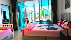 una camera con letto e vista sulla piscina di พลอยพูลวิลล่า ชะอำ 1 Ploy Poolvilla Cha-am 1 a Petchaburi