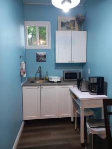 eine Küche mit weißen Schränken und einer blauen Wand in der Unterkunft Amor Bayridge in Kingston