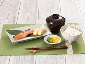 um prato de sushi e pauzinhos e uma tigela de arroz em HOTEL CHANT - Adult Only 大人専用 em Sakai