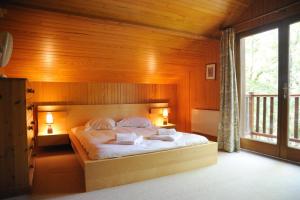 Lachapelle-AuzacにあるRésidence Souillac Golf & Country Clubの木製の壁のベッドルーム1室(大型ベッド1台付)