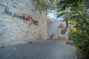 a brick wall with graffiti on the side of a building at The Jimbaran Villa by Ini Vie Hospitality in Jimbaran