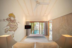 a bedroom with a bed with a painting on the wall at The Jimbaran Villa by Ini Vie Hospitality in Jimbaran +28 photos