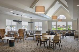 a dining room with tables and chairs and windows at Residence Inn Phoenix Glendale/ Peoria in Peoria