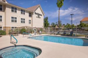 a swimming pool in front of a building with a hotel at Residence Inn Phoenix Glendale/ Peoria in Peoria