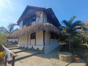 a small house with a thatched roof at El Paraiso de Carmen in Palomino