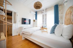 ein Schlafzimmer mit einem großen weißen Bett mit weißen Kissen in der Unterkunft MINIQ HOMES 101 - Phokaia Stone House with Sea View in Foça