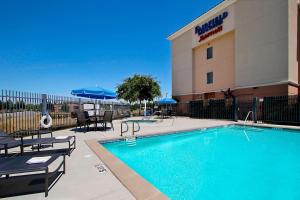 una piscina de hotel frente a un hotel en Fairfield Inn & Suites Fresno Clovis en Clovis